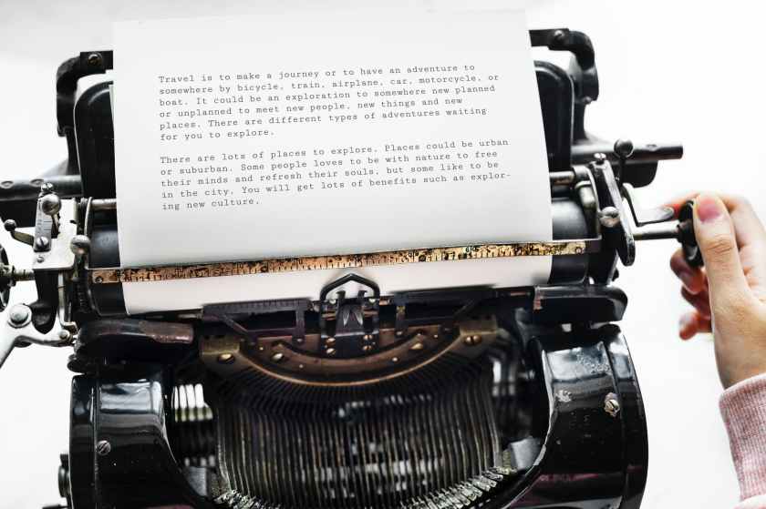 person holding black typewriter